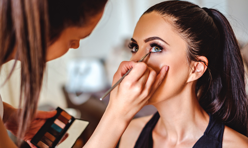 Makeup artist applying eyeshadow on a girl